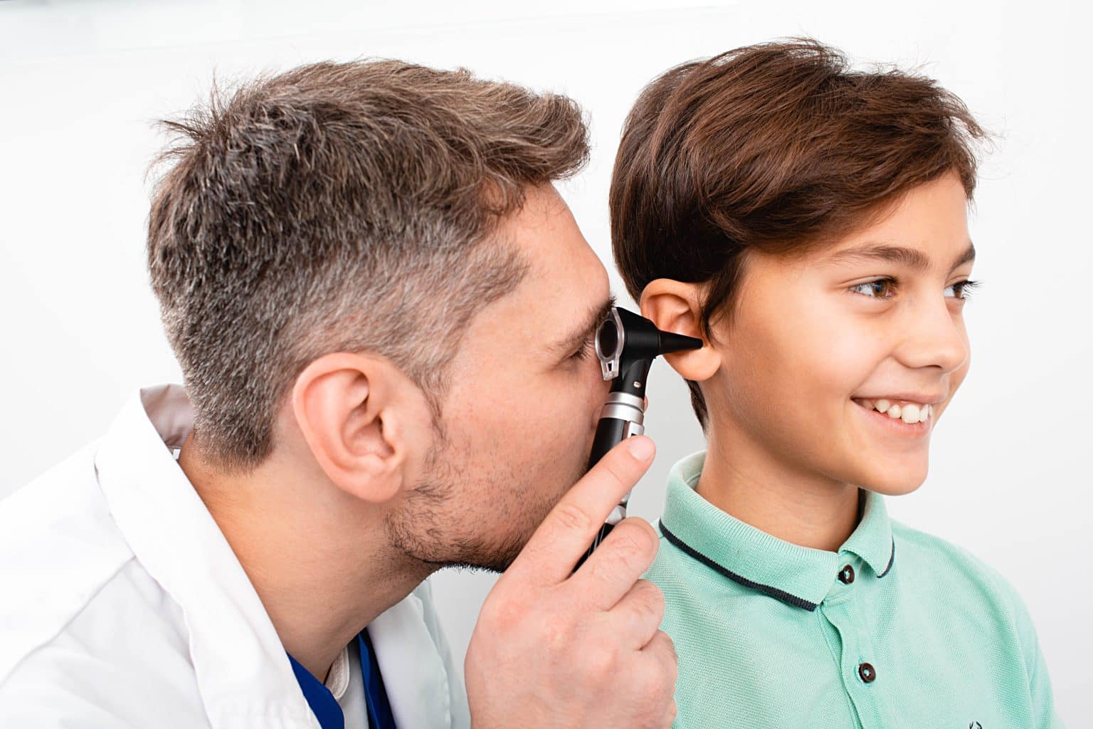 Doctor looking inside of a child's ear using a medical instrument